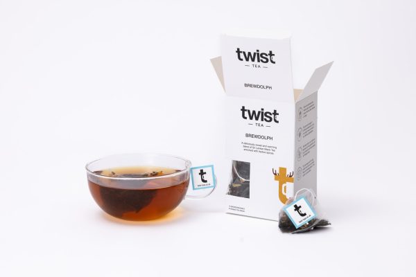 Brewdolph Christmas tea carton beside a cup of Brewdolph tea