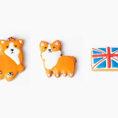 Three hand-iced gingerbread biscuits: King Corgi with a crown, Princess Corgi with pink detailing, and a Union Jack