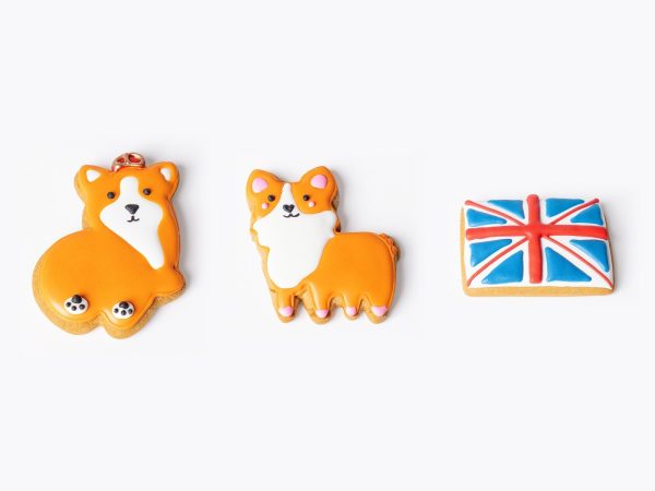 Three hand-iced gingerbread biscuits: King Corgi with a crown, Princess Corgi with pink detailing, and a Union Jack