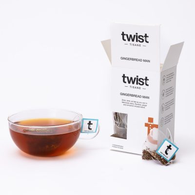 Gingerbread Man Christmas tea carton beside a cup of Gingerbread Man tea
