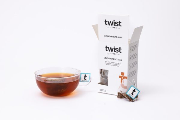 Gingerbread Man Christmas tea carton beside a cup of Gingerbread Man tea