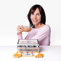 Claire with a cup of tea and the Twist Tea and Biscuits Caddy