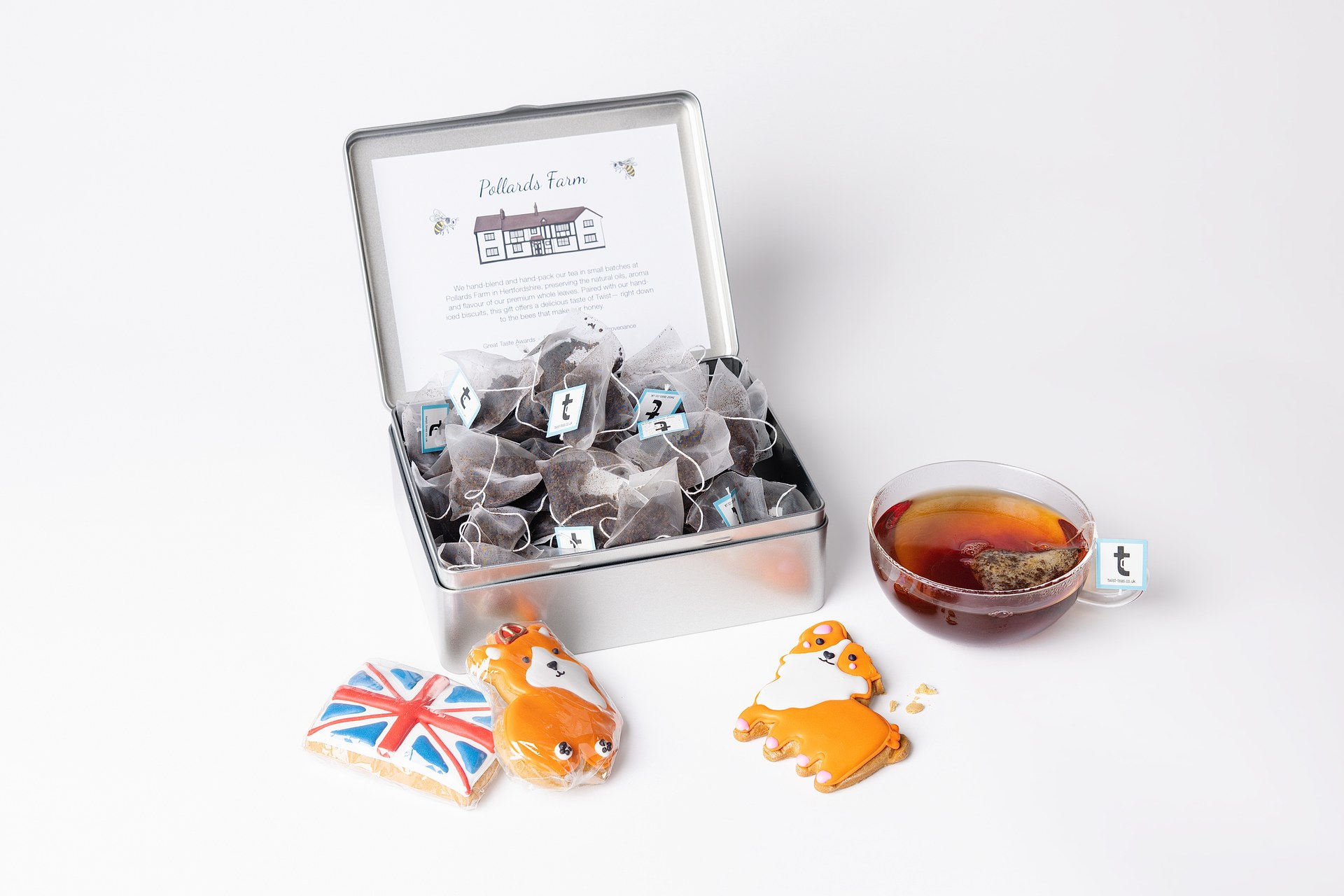 Twist Tea and Biscuits Caddy open, with corgi and Union Jack biscuits and a cup of tea