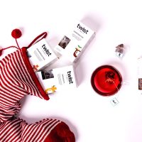 Christmas tea cartons spilling from a striped stocking beside a cup of Mulled Wine