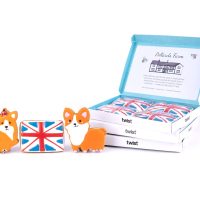 Hand-iced corgi and Union Jack gingerbread biscuits in front of three Twist biscuit boxes