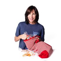 Claire from Twist Teas filling a striped stocking with individually wrapped hand-iced biscuits
