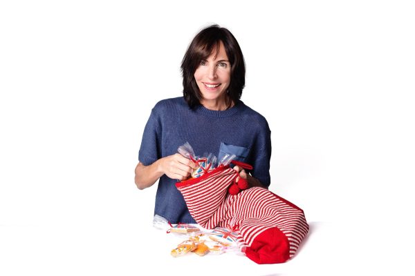 Claire from Twist Teas filling a striped stocking with individually wrapped hand-iced biscuits