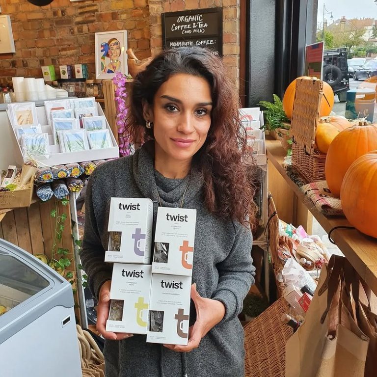 A woman holding four Twist tea cartons in a shop