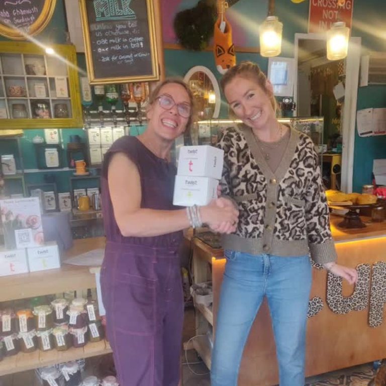 Two women in a shop holding a box of Twist tea